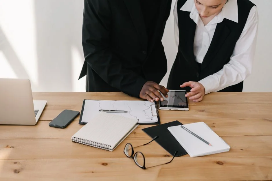 Deux collègues élaborent ensemble une stratégie marketing sur un tableau blanc, en mettant l’accent sur le contenu généré par les utilisateurs.